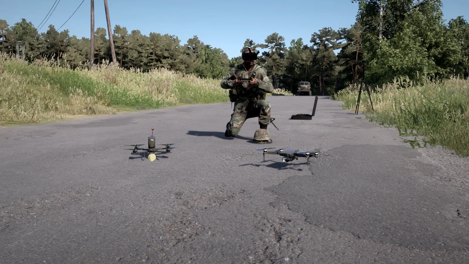 Drone de reconhecimento e FPV kamikaze no asfalto em primeiro plano, com o operador ajoelhado logo atrás, de óculos FPV e controle nas mãos, e a estação de comando com antena ao fundo